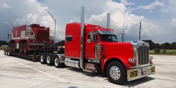 Red heavy-haul truck transporting oversized equipment